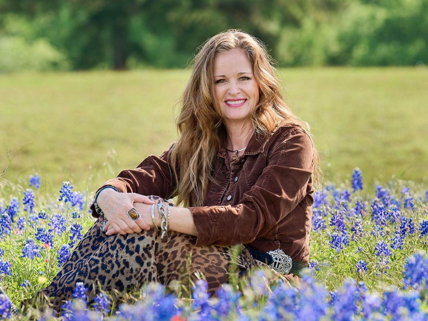 Susan Nogues sitting in a field of Texas bluebonnets